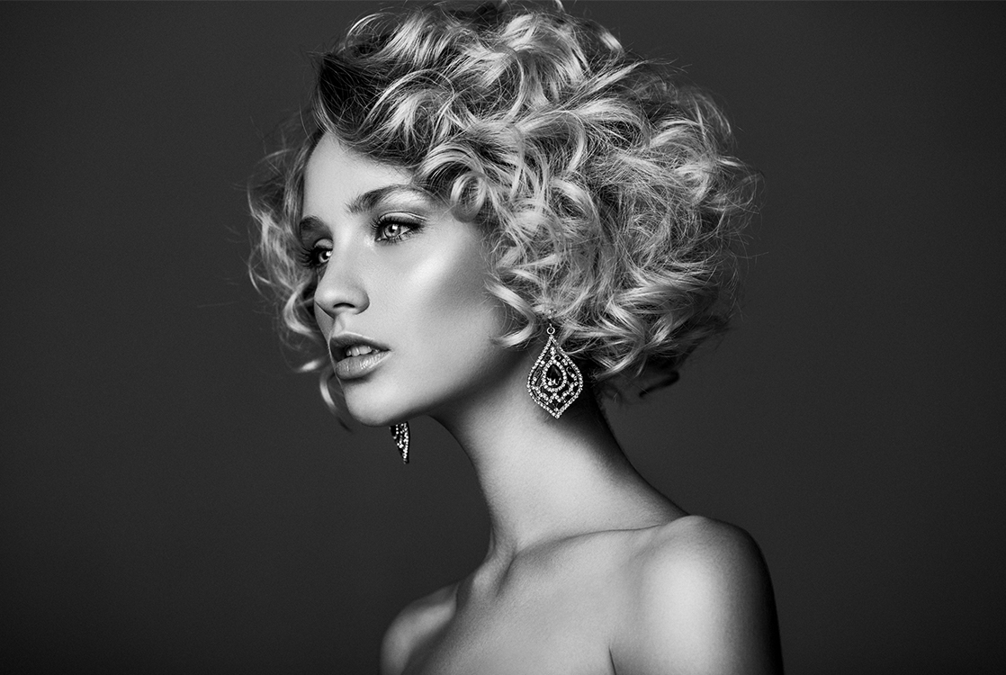 A black-and-white portrait of a woman with a sculpted jawline and prominent chin, representing the aesthetic results of chin augmentation.